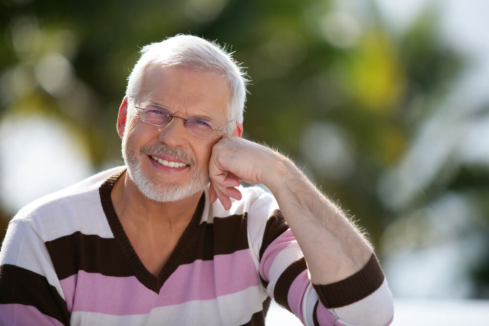 middle-age man smiling with hand to face