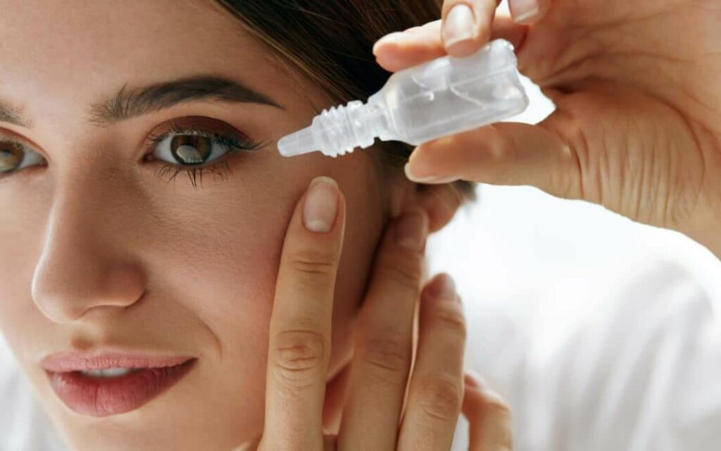 Woman putting eye drops in her eye