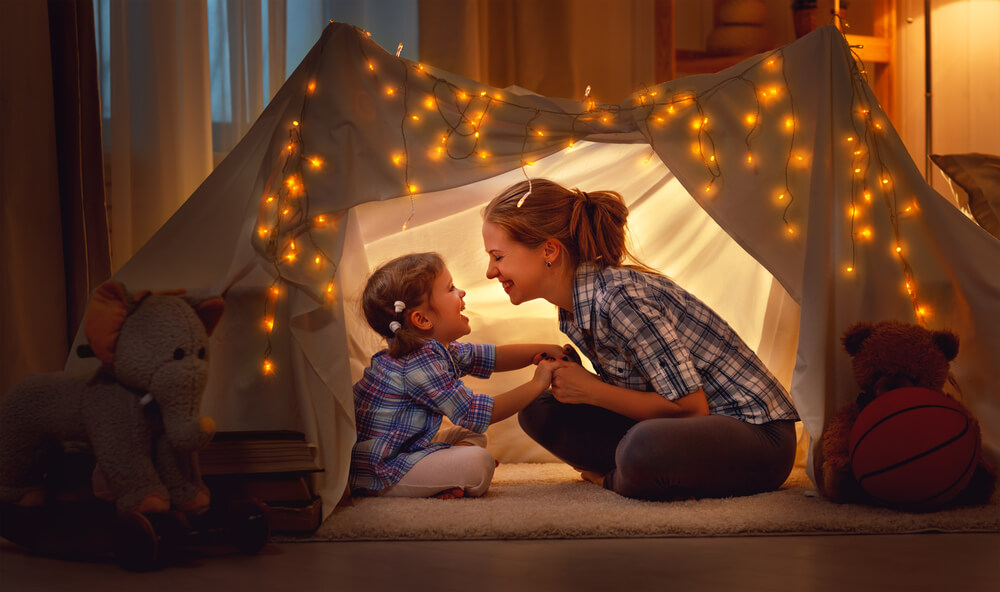 Woman and daughter in tent with lights