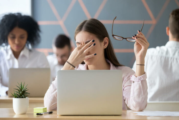 Rubbing dry eyes in front of computer