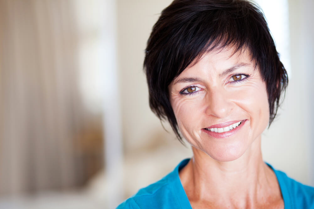 Mature woman with dark hair smiling