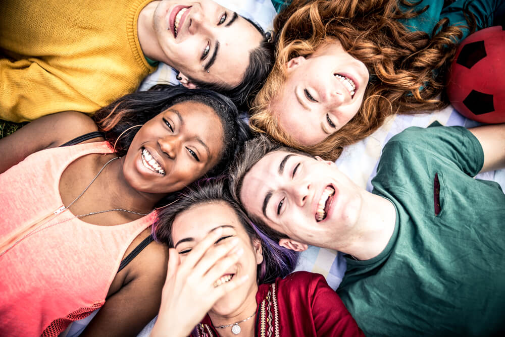 Group of teenagers looking up at camera and smiling